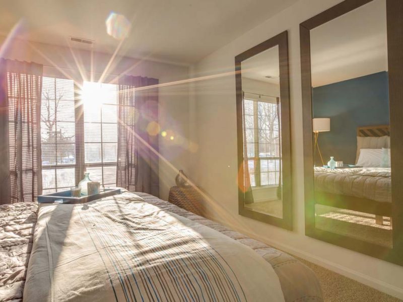 This image shows a spacious bedroom featuring the two big mirrors o the wall. Consider the glimpse of the stunning sunlight every morning that brightens your day.