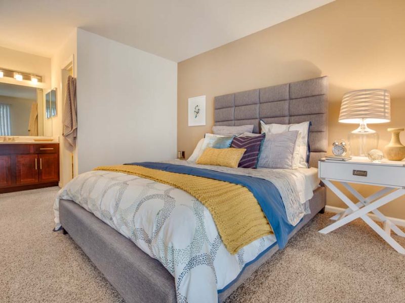 This image shows a master bedroom with modern lighting fixtures. It offers spacious floor plans with ample closet space and extra storage.