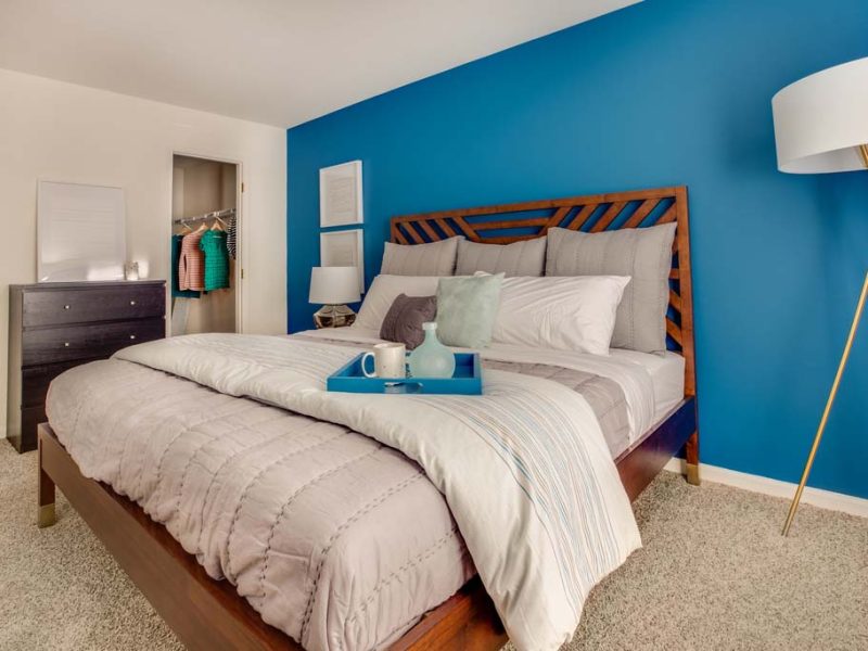 This image shows a spacious bedroom with large walk-in closets. It has large open floor plans with rustic design cabinet.