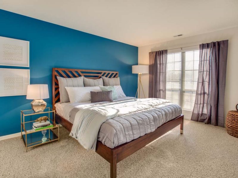 This image shows the bedroom area showcasing the light tone color wall, elegant fabrics, and an overlooking view outside that was ideal for a comfy pleasure.