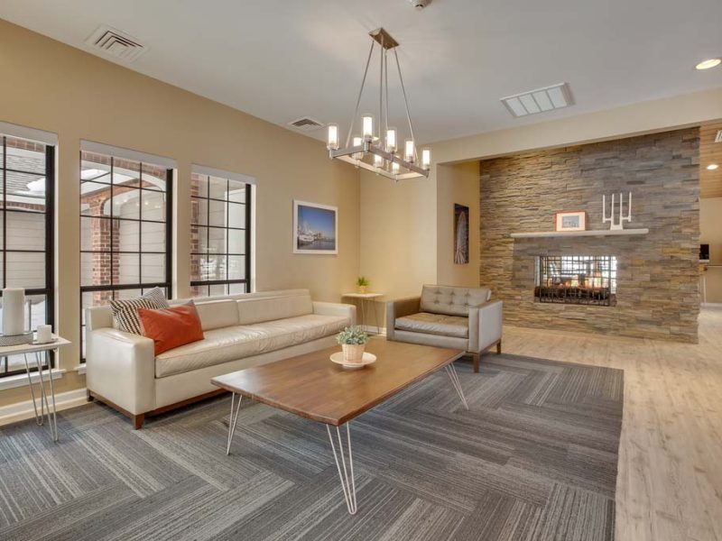 This image exhibits the club room area featuring the well-organized furniture, elegant wall decors, and an ideal indoor fireplace.