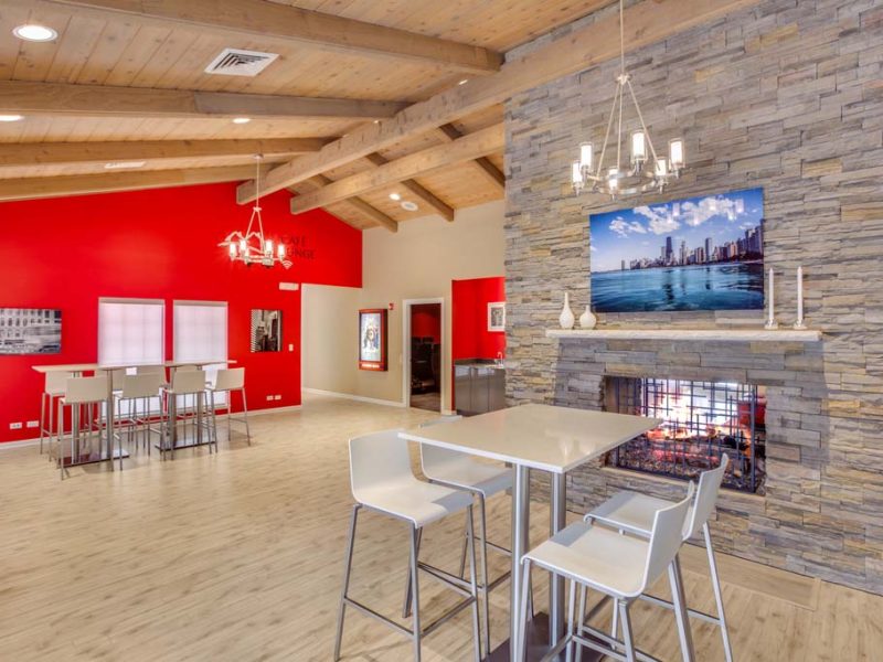 This image showcases the premium community amenities, particularly the café lounge featuring a complimentary coffee, wifi, comfy seats, and a fireplace.