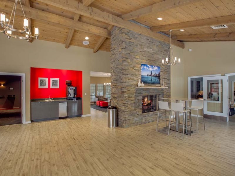 This image shows an expansive view of the clubhouse featuring a spacious café lounge, media center, apple computer bar, and comfy community seats.