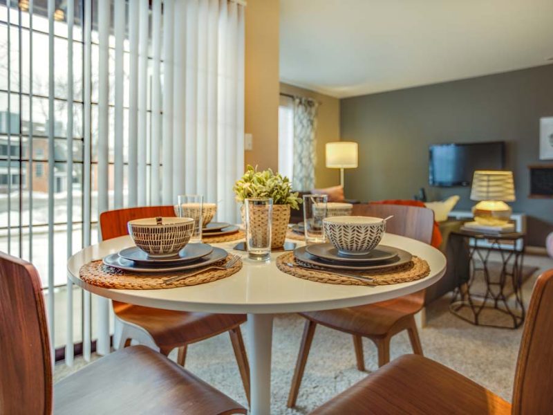 This image shows the dining room area featuring a luxurious minimal wall decor, stunning wooden chair and tables, and contemporary interior design.