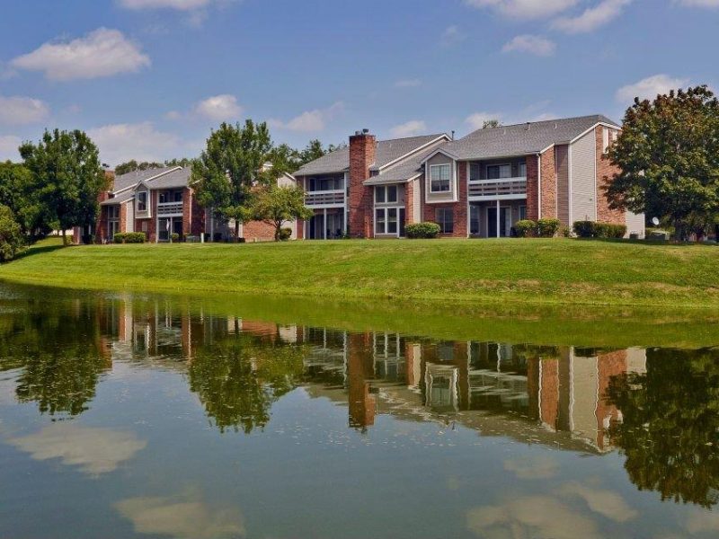 This image shows the pondside view of the TGM Willowbrook Apartments, featuring a green environment that's ideal for living.